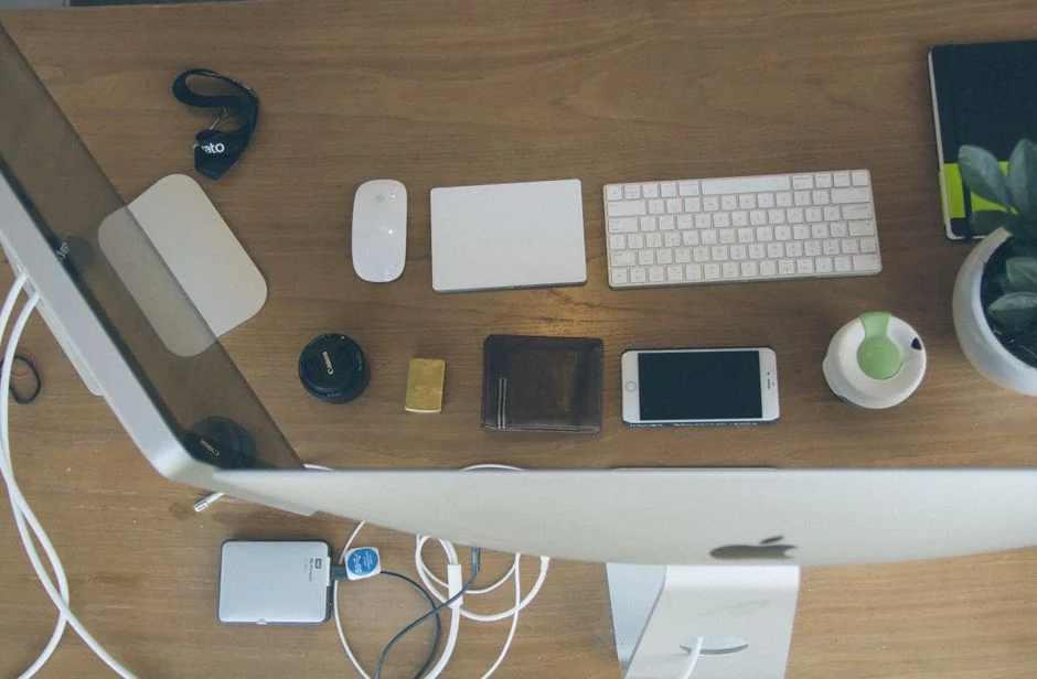 Un bureau lumineux avec un livre de design, un ordinateur portable et des outils créatifs, parfait pour stimuler l’inspiration.